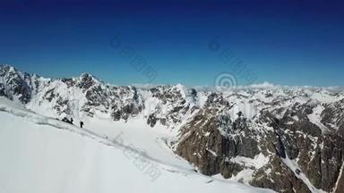 一架无人机在山上的一座雪崖上拍摄的全景。 两个登山者攀登高峰。